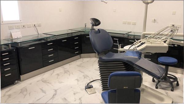 Foto mueble blanco en consultorio odontológico con sillón rojo